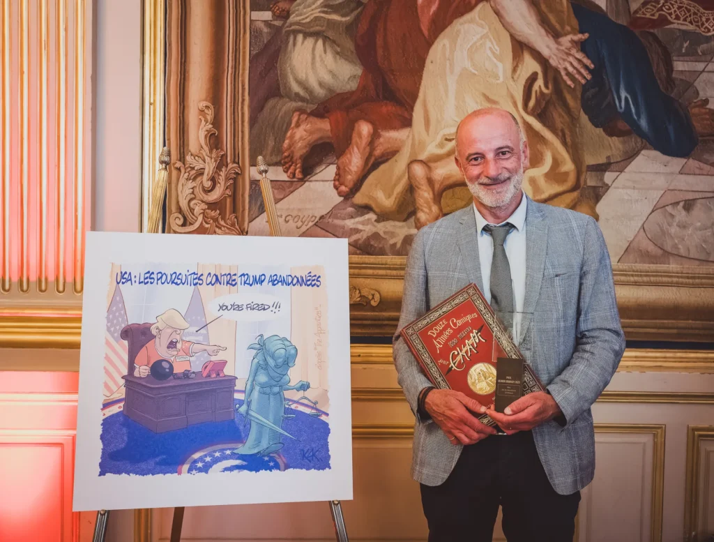 Intervenant souriant tenant un ouvrage à côté d'une illustration sur chevalet
