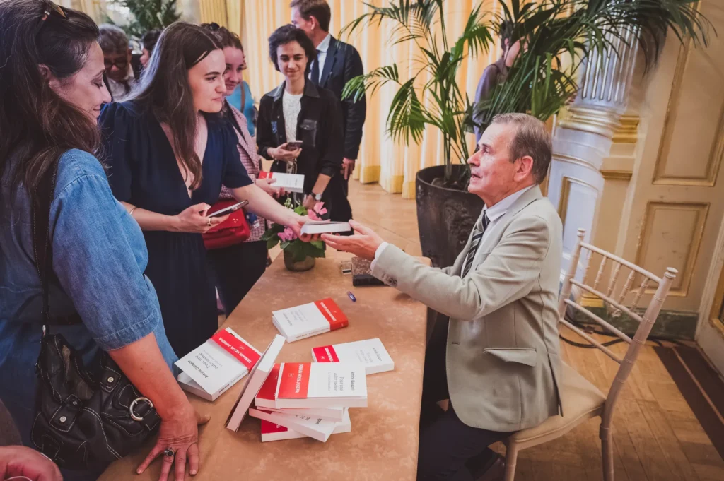 Séance de dédicace autour d'une table de livres lors du 14e Prix Olivier Debouzy