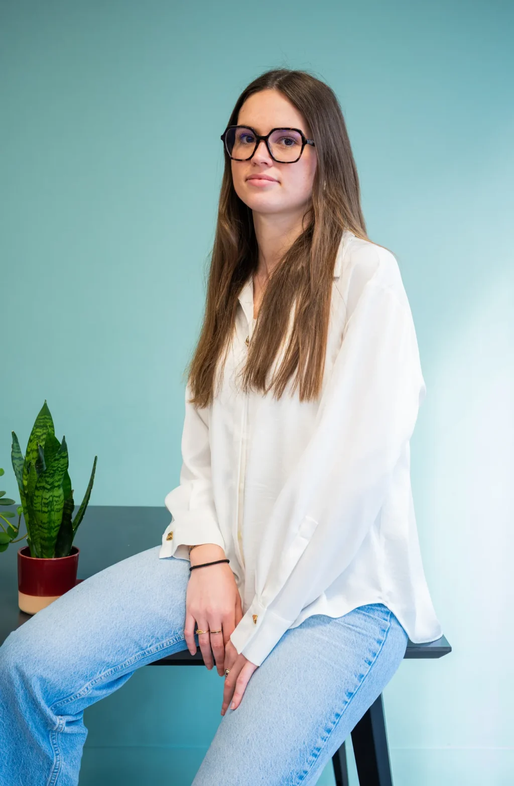 Portrait d'un membre de l'équipe FYGR à lunettes, en chemisier blanc