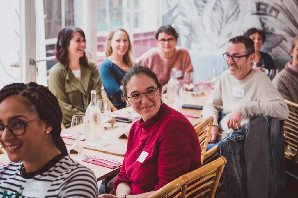 Convives souriants à table lors du déjeuner HomeExchange
