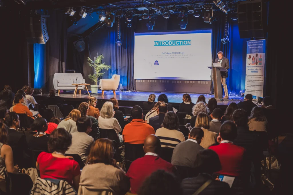 Salle comble pendant une conférence de la JIRSI 2025, intervenant sur scène face au public