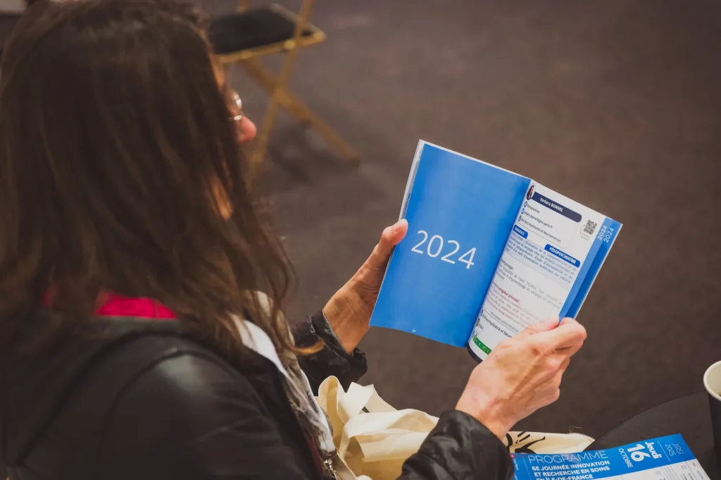 Participante consultant le programme de la JIRSI 2025