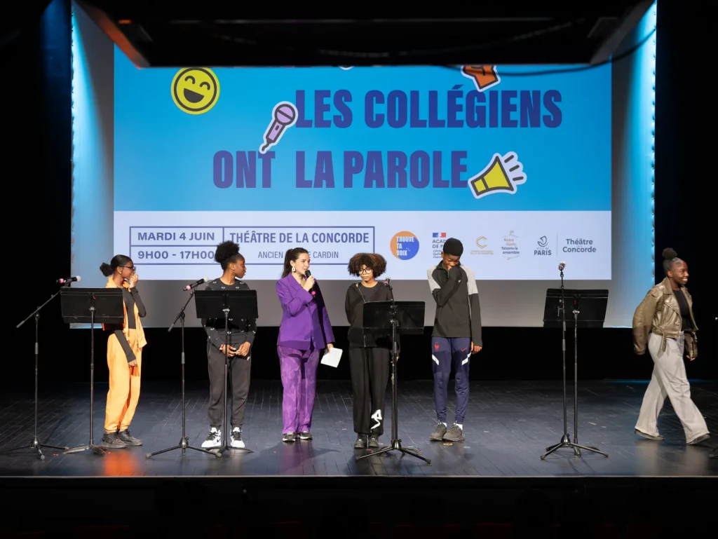 Élèves alignés sur scène devant l'écran du festival Les collégiens ont la parole
