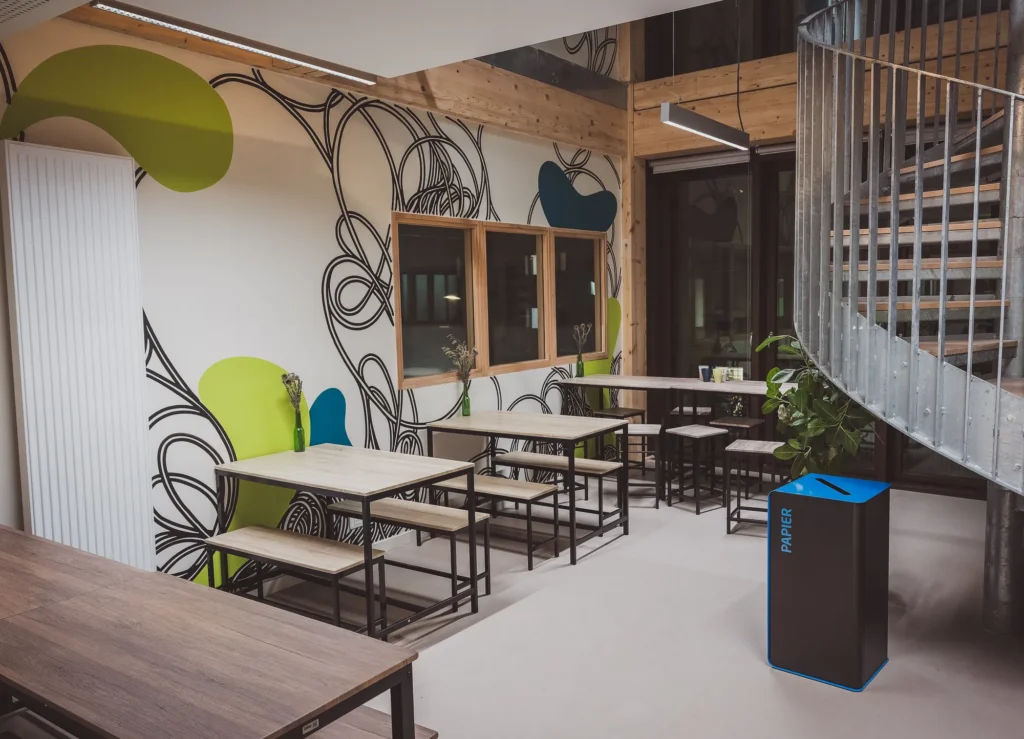 Espace de travail partagé avec tables et escalier au Wikivillage