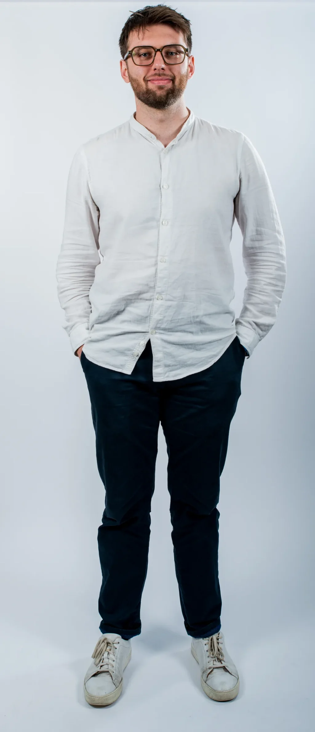 Portrait corporate en pied d'un membre de l'équipe Yabuko en chemise blanche, debout sur fond clair